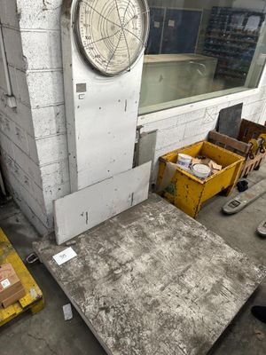 une horloge sur la façade d'un immeuble, à côté d'une pile de cartons