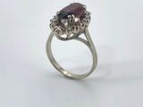 a close up of a ring with a red stone in it