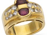 gros plan d'une bague en or avec un rubis et un diamant au centre