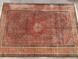 un tapis rouge orné d'un motif en médaillon posé sur un sol blanc