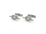 deux paires de boutons de manchette en argent sur fond blanc