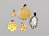 three gold and silver pendants and two silver and gold coins