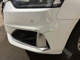 the front end of a white car with a denting front bumper