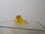 a yellow frog sitting on top of a glass table