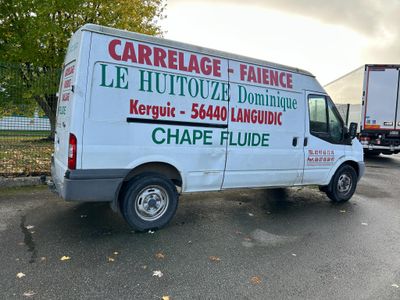 une camionnette blanche garée sur le parking