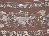 a close up of a piece of art with flowers on it