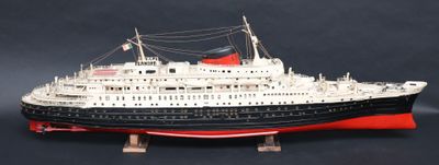 une maquette de bateau posée sur un socle, sur fond noir