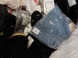 a pile of clothing and other items on a bed
