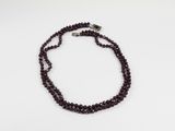 gros plan d'un collier de perles sur une surface blanche