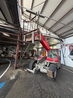 a red truck parked inside of a building with a ladder