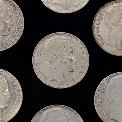 several silver coins with heads of people on them on a black surface