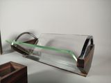 a glass vase with a green handle sitting on a table