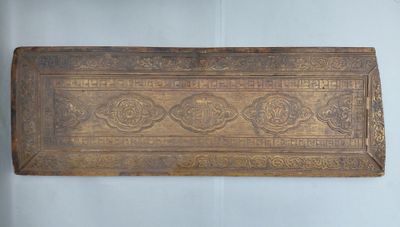 un vieux plateau en bois orné d'un motif décoratif