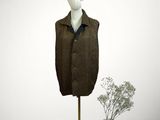 mannequin with hat and coat on stand next to a vase of flowers