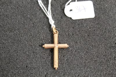 une croix en or suspendue à un cordon blanc, avec une étiquette de prix