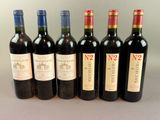 six bouteilles de vin sont alignées sur une table