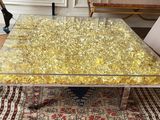 une table basse en verre ornée d'un motif à la feuille d'or