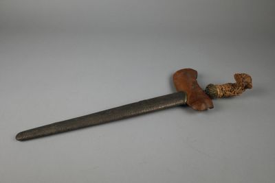 gros plan d'un couteau avec un manche en bois sur une surface blanche
