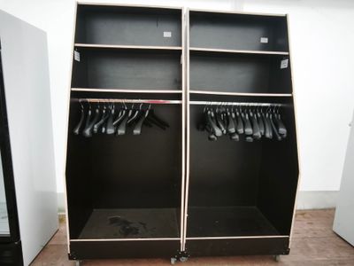 une armoire noire sur laquelle sont suspendus tout un tas de vêtements