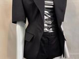 a mannequin dressed mannequin wearing a black jacket and skirt