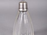 a clear glass bottle with a silver stopper on it