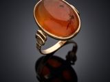 une bague en or ornée d'une pierre de cornaline au centre