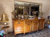 un grand miroir accroché au mur au-dessus d'une commode en bois