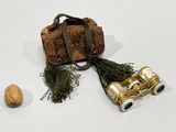 two binoculars and a walnut on a white surface