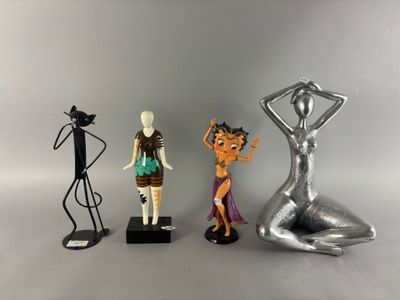 three figurines of a woman, a man and a cat on a table