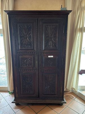 a tall wooden cabinet in the corner of a room