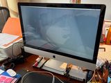 a computer monitor sitting on a desk with a keyboard and mouse