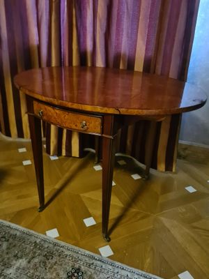 une table en bois sur laquelle se trouve un tiroir, devant un rideau