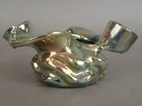 a silver vase that has a hat on top of it