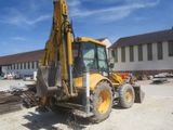a backhoe of a construction vehicle parked in a parking lot