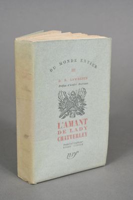 an old book sitting on top of a table on a gray surface