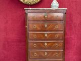 une petite commode avec un tableau accroché au mur derrière elle