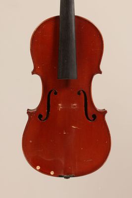 an old violin hanging from the back of a white wall