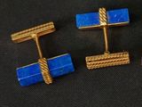 trois paires de boutons de manchette dorés et bleus sur fond noir