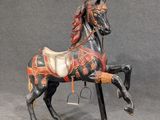 statue d'un cheval sellé, posée sur un socle, sur fond gris