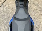 the back end of a blue and black motorcycle parked in a parking lot