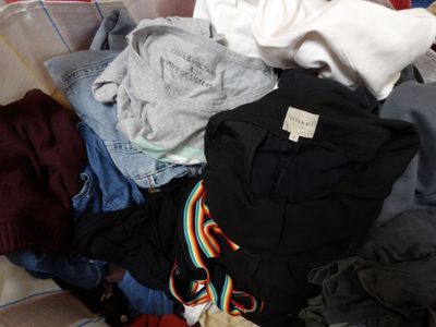 a pile of clothes that is on a bed