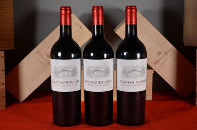 three bottles of red wine sitting on a table next to a wooden crate