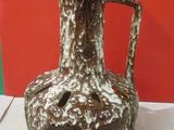 a brown and white vase sitting on a table