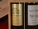two bottles of wine sitting in a wooden box