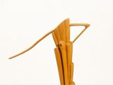 a wooden sculpture of a bird on a white surface