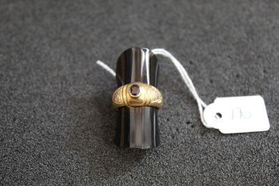 un petit objet en argent et en or muni d'une étiquette