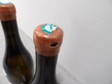 two bottles of wine sitting next to each other on a counter