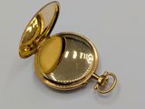 a gold pocket watch with a gold case on it