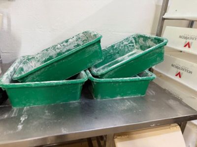 trois récipients verts posés sur une table en métal
