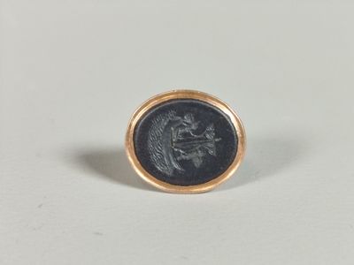 a close up of a gold ring with a coin on it
